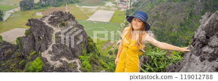 BANNER, LONG FORMAT Woman tourist on top pagoda of Hang Mua temple, rice fields, Ninh Binh, Vietnam. Vietnam reopens borders after quarantine Coronovirus COVID 19 BANNER, LONG FORMAT Woman tourist on top pagoda of Hang Mua temple, rice fields, Ninh Binh, Vietnam. Vietnam reopens borders after quarantine Coronovirus COVID 19 119012788