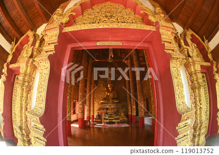 A large Buddha image sits in a golden color. Inside Buddhist Church at Wat Phra Phutthabat Tak Pha temple. This temple is an important place of worship in Lamphun Province , Northern of Thailand. 119013752