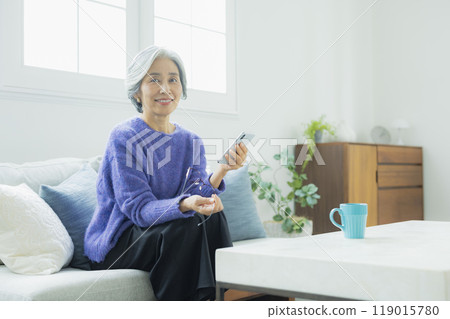一位身穿針織品的高級女性在客廳放鬆 119015780