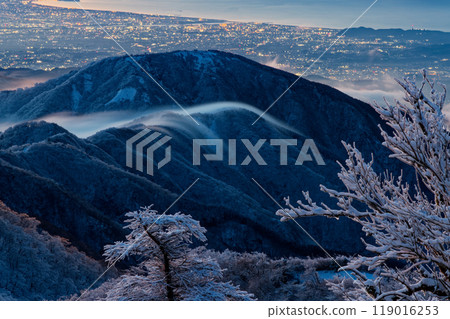 View of the waterfall clouds flowing along the Omote Ridge and the Shonan city lights at dawn from Mt. Tonodake in Tanzawa 119016253