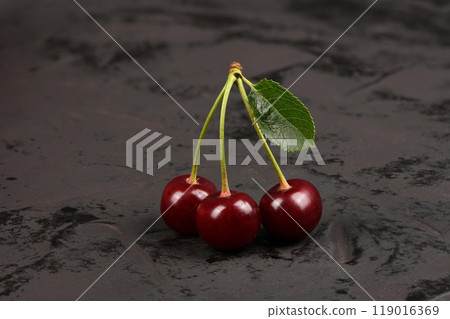 Fresh red cherries with green leaves isolated on black background.  Natural background. 119016369