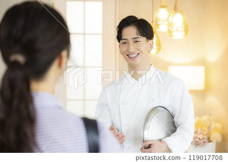 A young man wearing a chef's coat 119017708