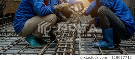 A group of builders is busy constructing a metal structure 119017713