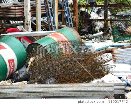 A pile of garbage with a bucket, rope, bottles, and other items at a landfill 119017742