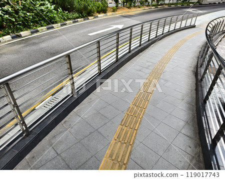 Curved path with guardrail and yellow line for blind people along the road Curved path with guardrail and yellow line for blind people along the road 119017743