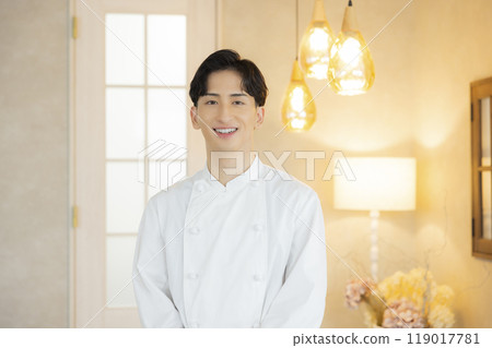 A young man wearing a chef's coat 119017781