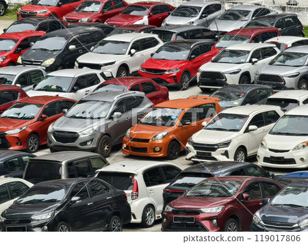 There are a great number of cars parked in a large parking lot 119017806