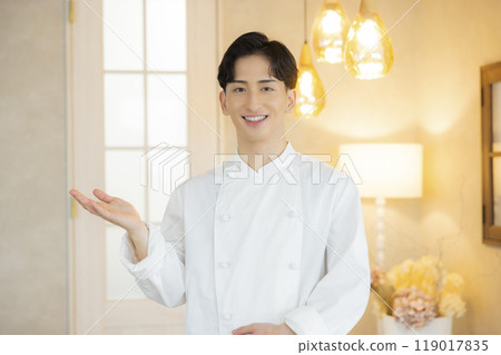 A young man wearing a chef's coat 119017835