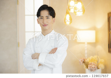 A young man wearing a chef's coat 119017837