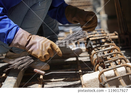 A group of builders is busy constructing a metal structure 119017927