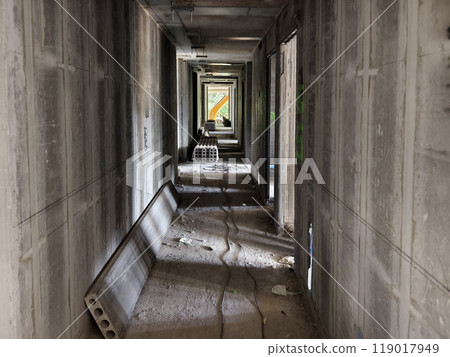 A long hallway featuring sturdy concrete walls and floor 119017949