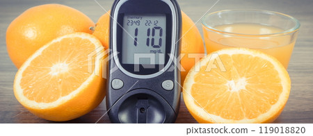 Glucometer with sugar level, fresh fruits and orange juice. Source natural minerals and vitamins Glucometer with sugar level, fresh fruits and orange juice. Source natural minerals and vitamins 119018820