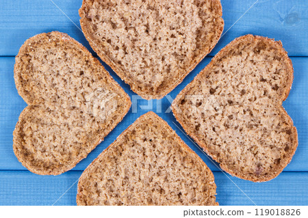 Fresh wholegrain bread in shape of heart for breakfast. Blue boards 119018826