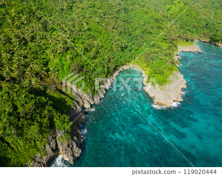 Waves crashing on rocky coastal with turquoise sea water and corals. San Jose Island. Romblon, Philippines. 119020444