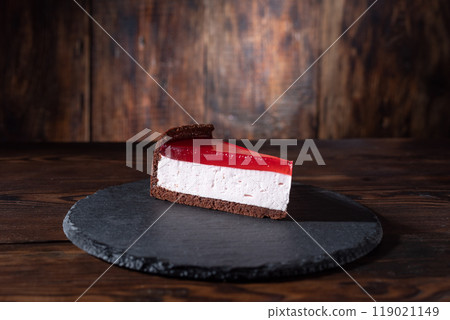 Cheesecake with red marmalade. Cake on a slate tray. A piece of cake with marmalade. 119021149