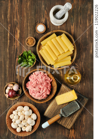 Preparing ingredients for homemade lasagna with ground meat, mushrooms, and cheese 119022226
