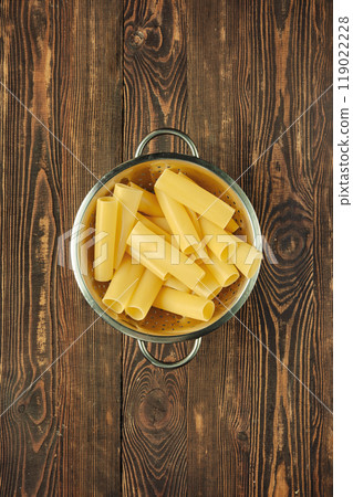 Cooking fresh cannelloni pasta in a colander on a rustic wooden surface after boiling Cooking fresh cannelloni pasta in a colander on a rustic wooden surface after boiling 119022228
