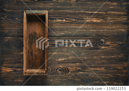 A rustic wooden box placed on a dark wooden table highlighting craftsmanship and texture 119022253