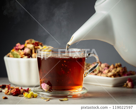 Hot herbal tea is poured into a mug. Hot herbal tea is poured into a mug. 119022597