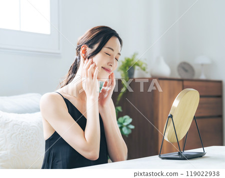 一個女人在室內照鏡子做皮膚護理 一個女人在室內照鏡子做皮膚護理 119022938