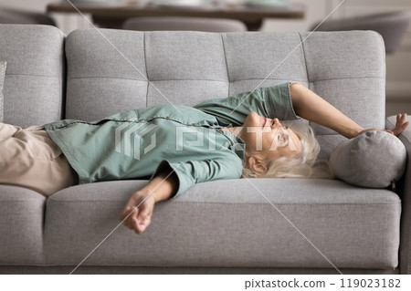 Tired older woman felt asleep on couch Tired older woman felt asleep on couch 119023182