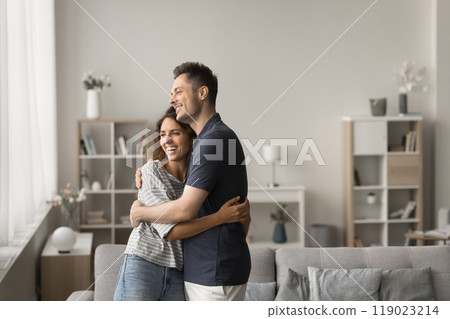 Happy young family couple standing in comfortable home interior 119023214
