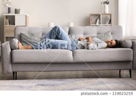 Peaceful sleepy beautiful young woman lying on back 119023259