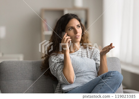 Pretty young Latin woman speaking on mobile phone at home 119023385