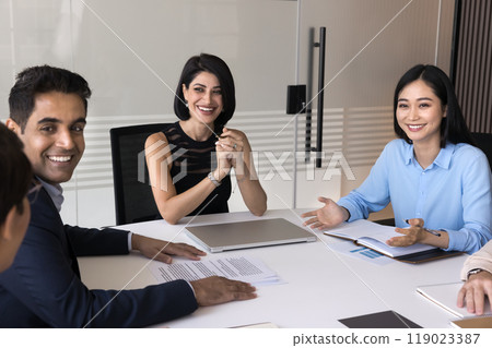 Cheerful multiethnic team of managers and boss meeting at table Cheerful multiethnic team of managers and boss meeting at table 119023387