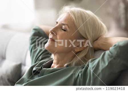 Close up serene elderly woman relaxing comfortable in cozy environment Close up serene elderly woman relaxing comfortable in cozy environment 119023418