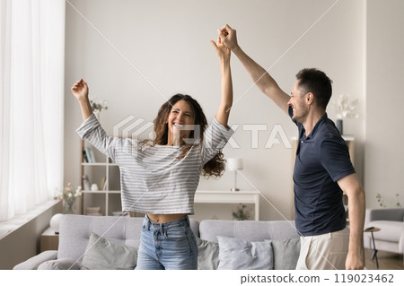 Positive young husband and wife having fun at new home Positive young husband and wife having fun at new home 119023462