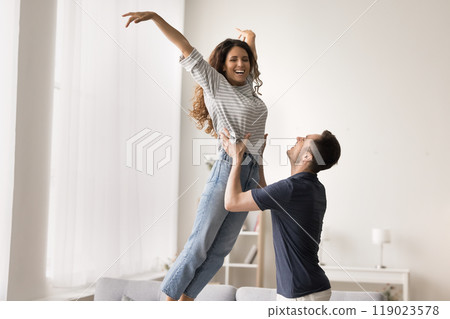 Happy strong husband lifting slim Latin wife in dance 119023578
