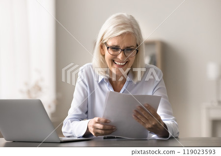 Older woman read document about positive financial statement 119023593
