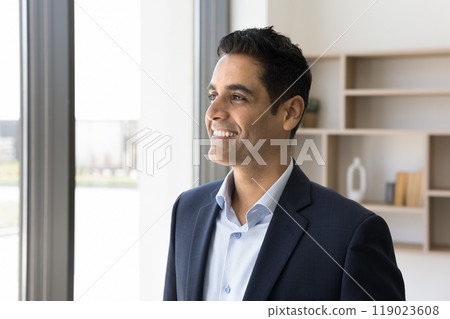 Happy young Indian man in formal suit look at window Happy young Indian man in formal suit look at window 119023608
