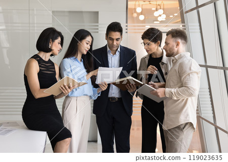 Diverse business team of focused coworkers analyzing document 119023635