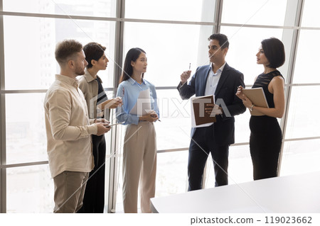Indian business leader talking to diverse managers in meeting room Indian business leader talking to diverse managers in meeting room 119023662