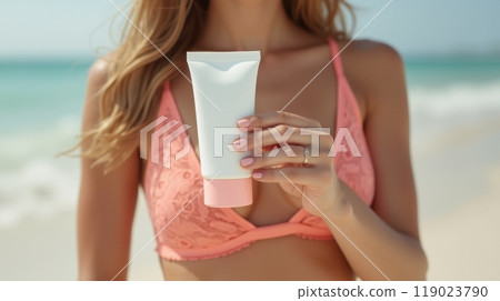 Model in pink lace bikini holding a white sunscreen tube, promoting skincare and sun protection in a fresh, beachy vibe 119023790