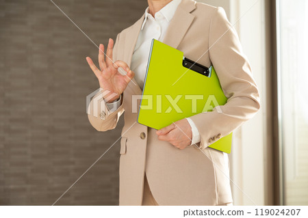 A real estate saleswoman making a circle sign inside an apartment building 119024207