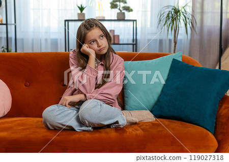 Tired preteen teenage kid thinking dreaming imagining leaning head on hand boredom disinterest 119027318