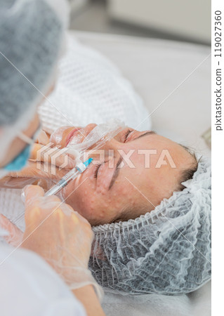 Cosmetologist making young woman beauty anti-aging injections biorevitalization face mesotherapy 119027360