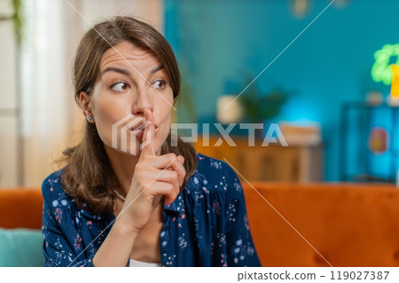 Woman presses index finger to lips makes silence quiet hush gesture sign do not tell gossip secret Woman presses index finger to lips makes silence quiet hush gesture sign do not tell gossip secret 119027387