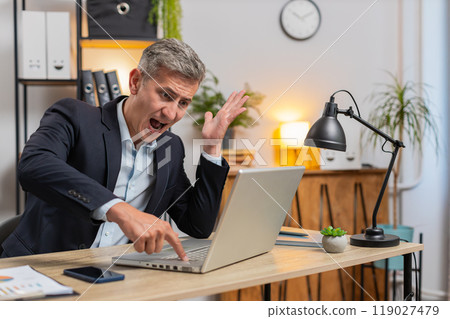 Frustrated Caucasian young entrepreneur having software problems with laptop at home office desk Frustrated Caucasian young entrepreneur having software problems with laptop at home office desk 119027479