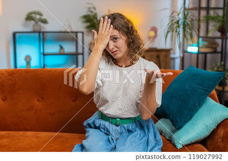 Upset woman making disrespect gesture, disappointed in fail results bad news on sofa couch at home 119027992