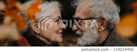 Happy elderly couple smiling while looking at each other in autumn nature 119029492