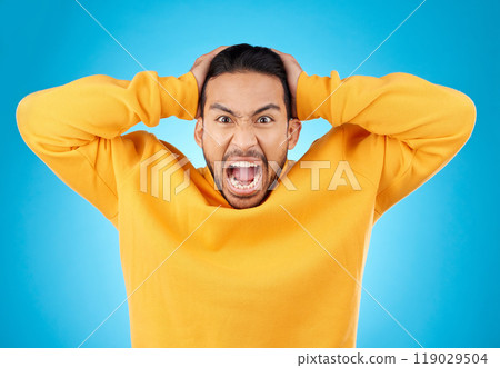 Angry, man and portrait with screaming in studio with burnout, anxiety and stress. Mental health, blue background and frustrated male person with yelling with anger about problem, mistake and issue 119029504