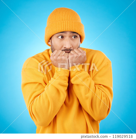 Nervous, anxiety and asian man biting nails in studio with terror, fear and scared for secret phobia on blue background. Stress, suspense and male person waiting for horror, danger alarm or bad news 119029518