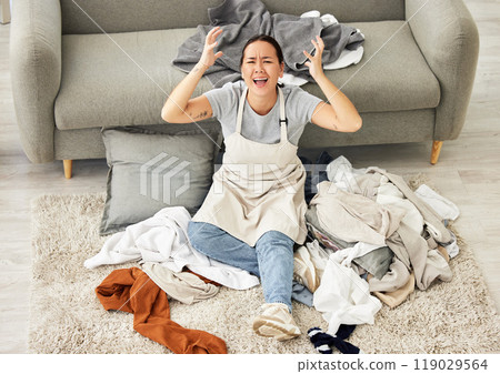 Frustrated, woman and cleaning dirty laundry in living room pr pile of messy clothes on floor. Asian maid, housekeeper or overwhelmed girl with housework, washing and stress clean from above 119029564