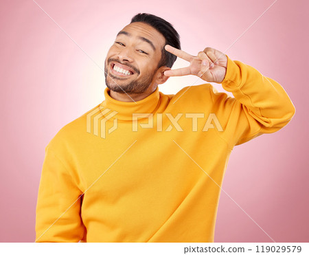 Happy, peace sign and portrait of man in studio for support, kindness and emoji. Smile, happiness and thank you with face of person on pink background for mindfulness, vote and v hand gesture 119029579
