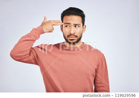 Frustrated, depression and man with gun gesture or stress with mental health or emotion in grey background in studio. Male person, shooting and head with anger or problem with anxiety and fear. 119029596