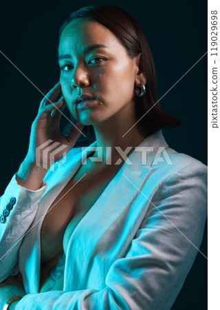 Neon, beauty and portrait of woman in studio with blue light for stylish, classy or formal fashion. Style, cosmetic and young Asian female model with makeup and fancy blazer by dark black background. 119029698
